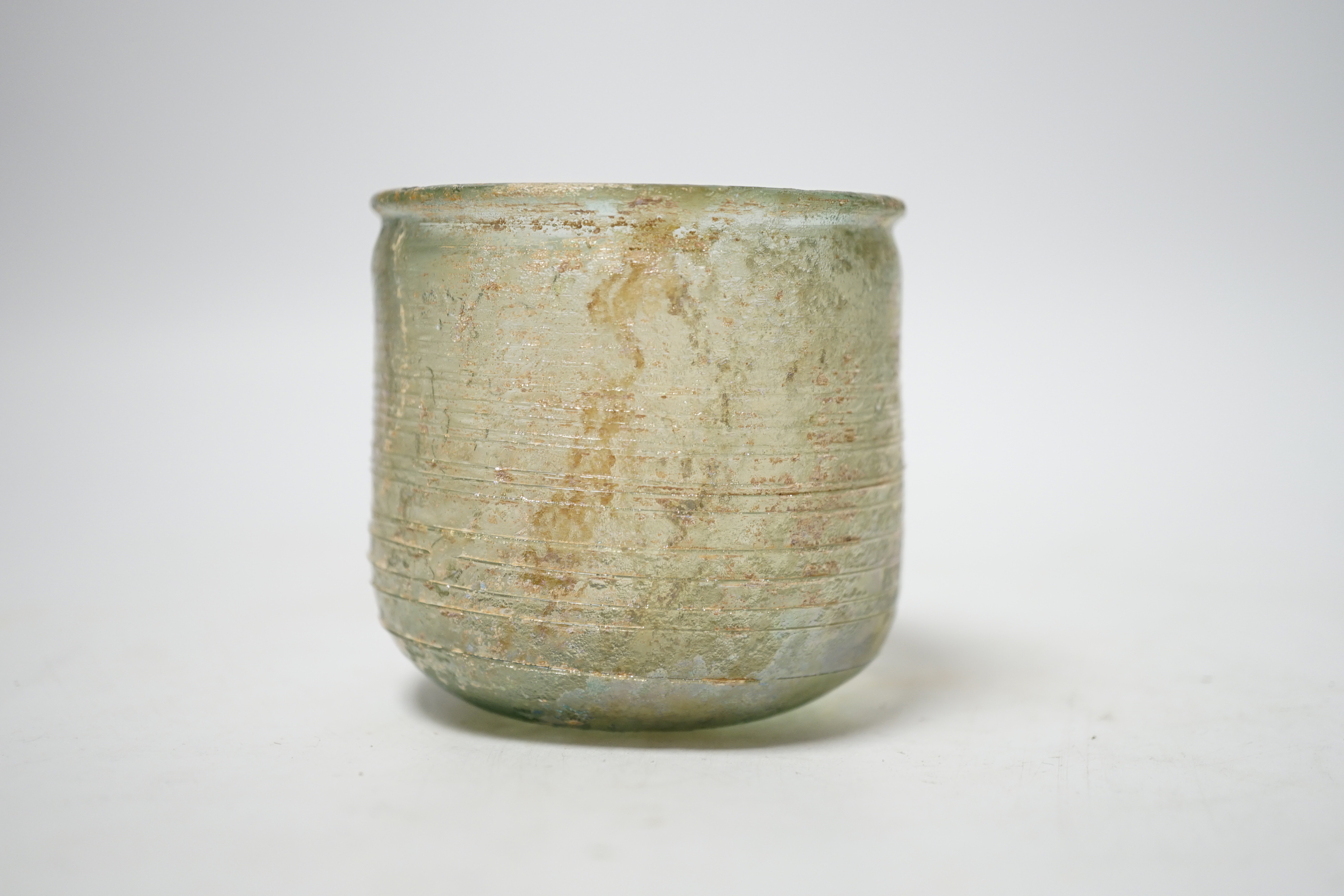 A Roman iridescent glass cup or tumbler, probably 2nd century AD, 7cm